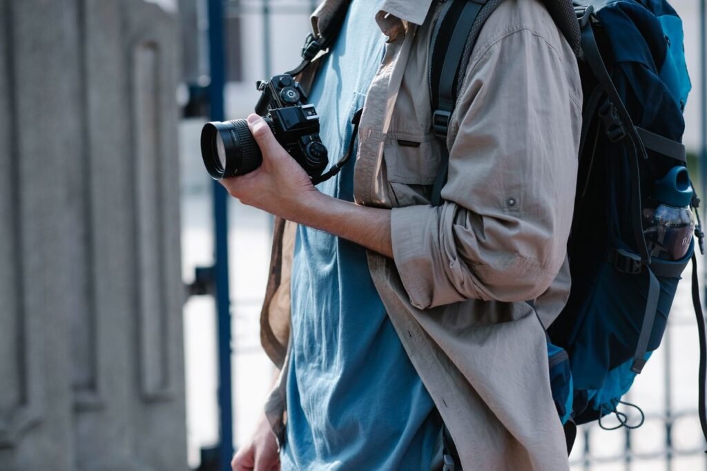 Close-up of a traveler with camera and backpack, exploring a city.