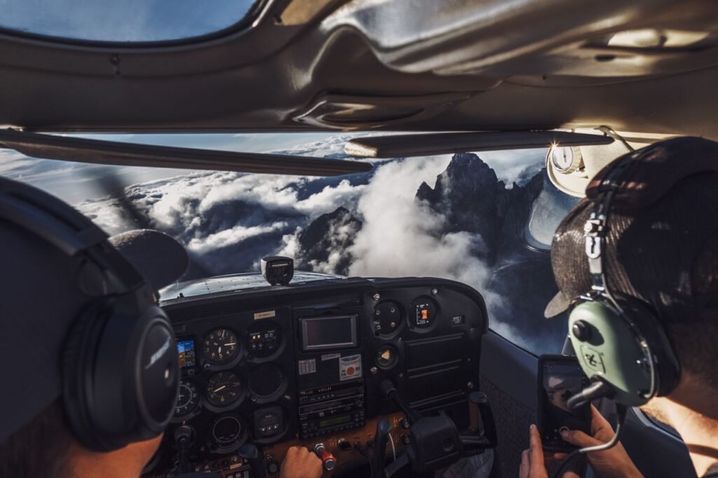 Pilot's perspective of flying over clouds and mountains, capturing the breathtaking view.